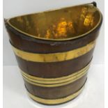 A 19th Century mahogany and brass bound navette form bucket with brass liner and narrow swing