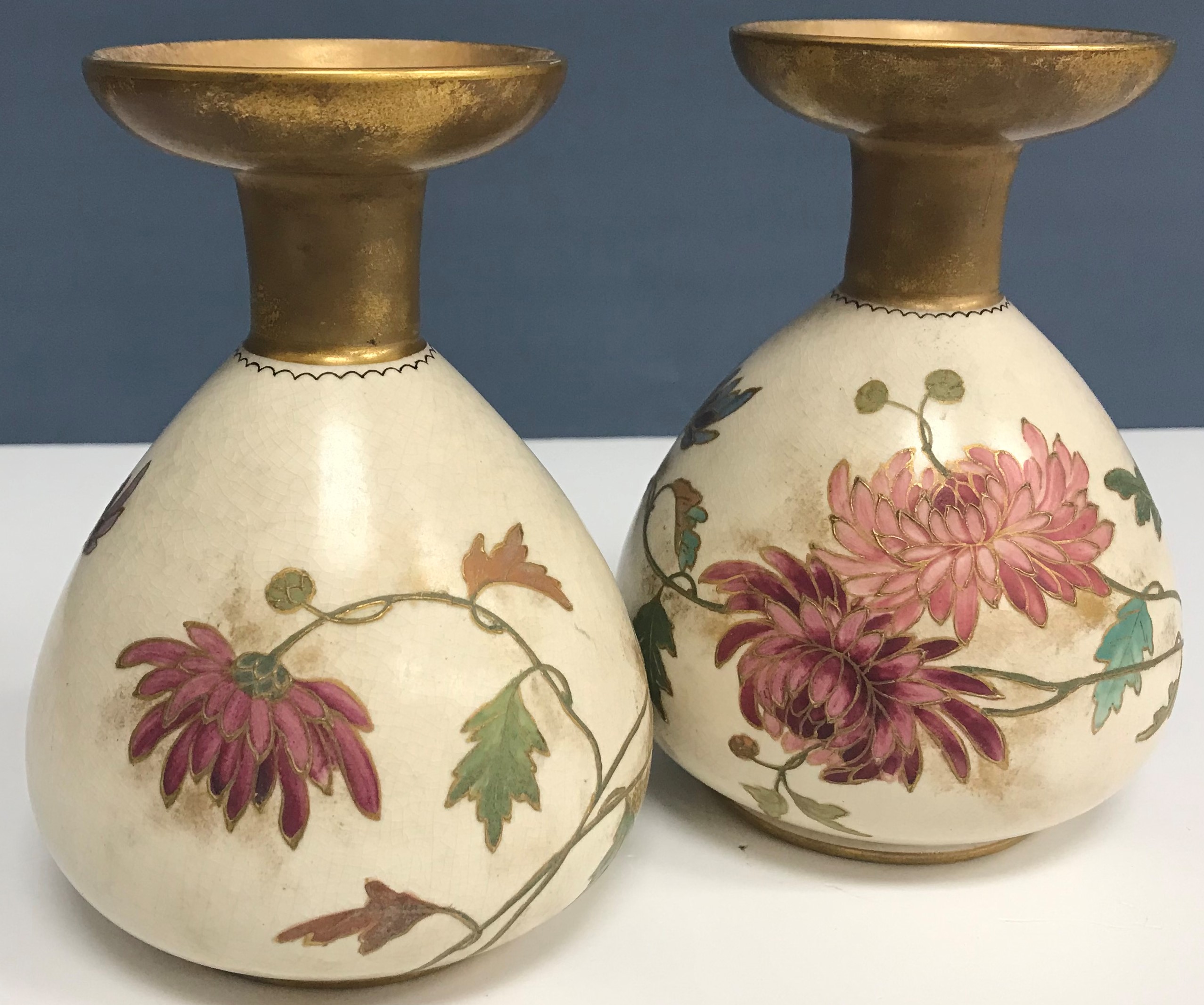 A pair of Royal Doulton Art ware floral decorated vases together with a matching larger example,