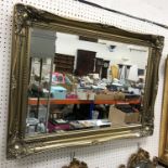 A modern gilt swept framed wall mirror with rectangular bevel edge plate 91 cm x 64.