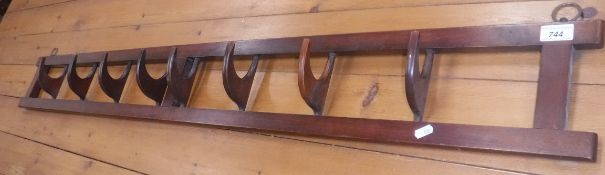 An early 20th Century mahogany wall mounted hat and coat rack of rectangular form with eight