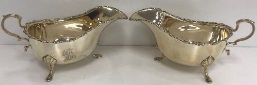 A pair of George V silver sauceboats in the 18th Century style with shell and scroll work decorated