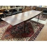 A 1970s rosewood rectangular extending dining table of shallow elliptical form,