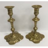 A pair of 18th Century brass candlesticks on square petal form bases 21.