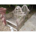 A pair of teak Lutyens style garden elbow chairs 102 cm high