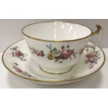 An early 19th Century Swansea Pottery tea cup and saucer with floral spray decoration and gilt