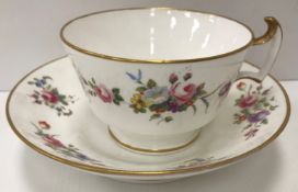 An early 19th Century Swansea Pottery tea cup and saucer with floral spray decoration and gilt
