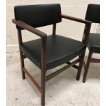 A set of six 1970s rosewood framed dining chairs with upholstered back panels and seats in black,