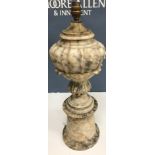 A basket containing a grey veined white marble pedestal table lamp,