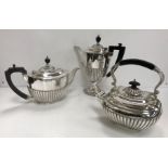 A plated tea pot and a plated coffee pot of oval form with reeded decoration and ebonised handles