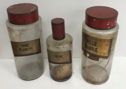 A collection of various glassware to include three cylindrical storage jars with painted tin covers