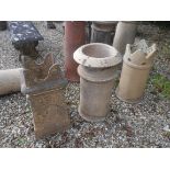 A collection of three terracotta chimney pots, two with castellated decoration,