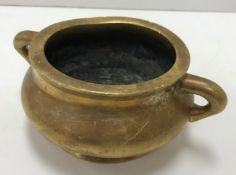 A Chinese polished brass censer of bellied form with openwork handles,