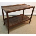 A 1970s rosewood two tier tea trolley with raised sides on rectangular supports united by an
