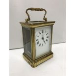 An early 20th Century brass cased carriage clock, the enamelled dial set with Roman numerals,