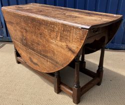 An 18th Century oak oval gate-leg drop-leaf dining table on turned unusually fluted tapering legs