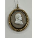 A George IV yellow metal mounted cameo brooch with central portrait bust of a gentleman on a smoky