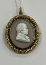 A George IV yellow metal mounted cameo brooch with central portrait bust of a gentleman on a smoky