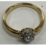 A yellow metal set diamond cluster ring size M/N of flower head form set with eight small stones