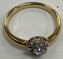 A yellow metal set diamond cluster ring size M/N of flower head form set with eight small stones