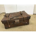 A Victorian heavy leather suitcase, opening to reveal a canvas-lined interior,