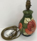 A Moorcroft floral decorated green ground tube lined table lamp with bayonet fixing approx.