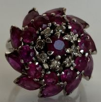 An 18 carat white gold flower head cluster ring set with ten navette cut rubies,