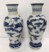 A pair of 19th Century Chinese blue and white baluster shaped vases with flared rims raised on