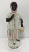 A 19th Century Staffordshire pottery figure "Aunt Chloe" stood in a headscarf with a fully laden