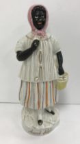 A 19th Century Staffordshire pottery figure "Aunt Chloe" stood in a headscarf with a fully laden