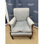 An Edwardian upholstered show frame scroll arm chair on turned and fluted tapering front legs to