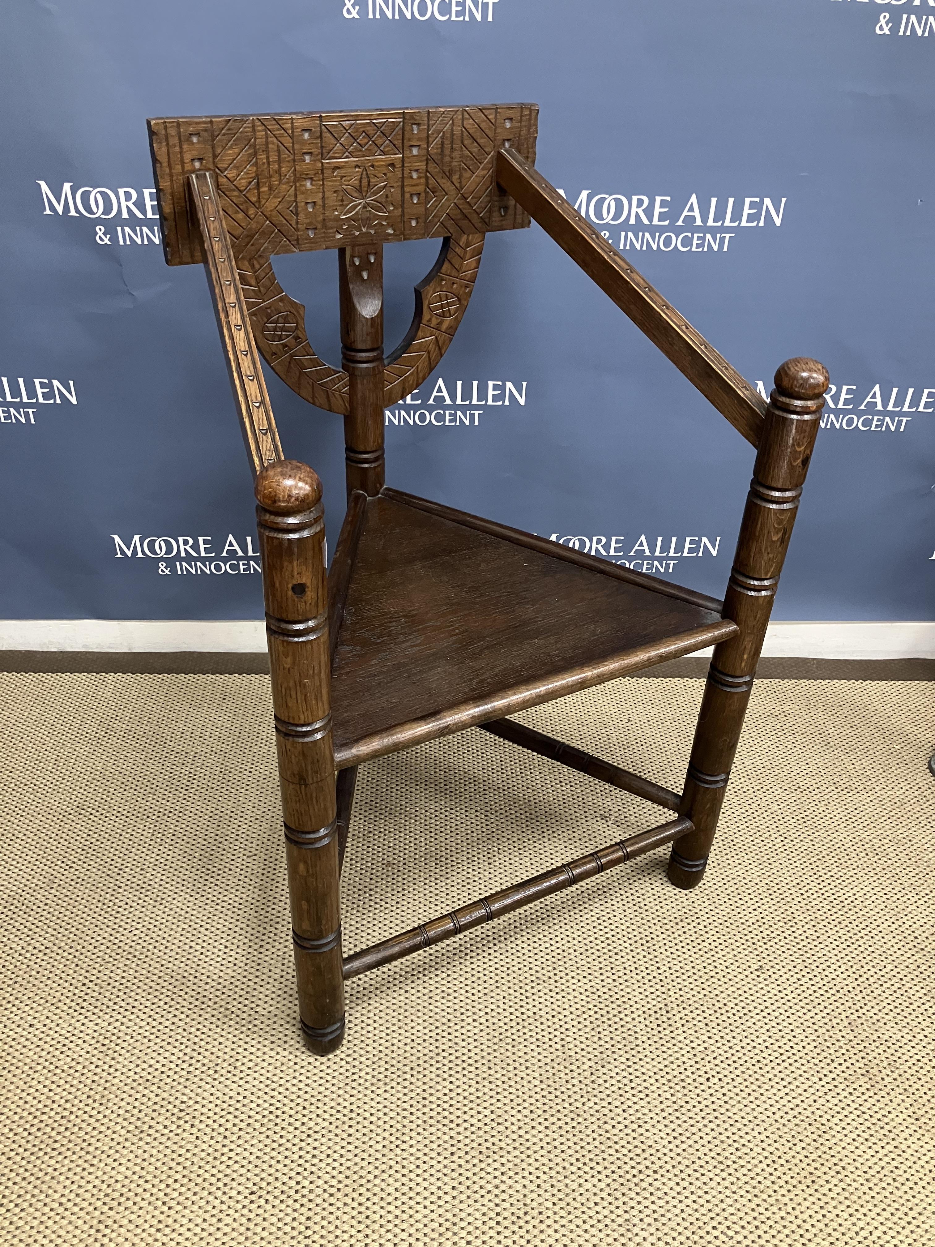 An oak corner chair in the 17th Century style with carved back rail above a panel seat on turned - Image 2 of 2