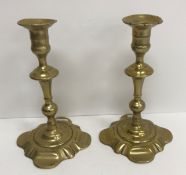 A pair of 18th Century brass candlesticks on square petal form bases 21.