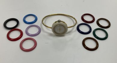 A Gucci gold-plated bangle watch with eleven interchangeable coloured plastic bezels (NB no box or