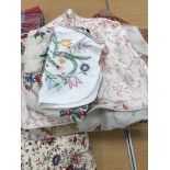 Two boxes of mainly household textiles to include vintage tablecloths, tea towels, aprons, etc.