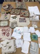 A box containing a collection of early to mid 20th Century table linens, cushion covers, trim,