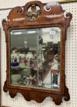 An 18th Century walnut veneered fretwork carved wall mirror with foliate gilt carved medallion