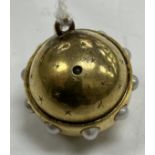 A late Victorian yellow metal and seed pearl mounted celestial globe pendant set with stanhope