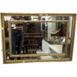 An early 19th Century carved giltwood and gesso framed ribbon decorated rectangular wall mirror, 81.