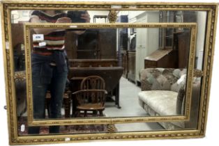 An early 19th Century carved giltwood and gesso framed ribbon decorated rectangular wall mirror, 81.