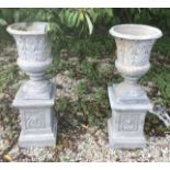 A pair of Art Nouveau style composite stone garden urns on stands 97 cm high