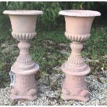 A pair of composite stone terracotta style Victorian style garden urns on stands 106 cm high