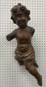 An 18th Century Continental carved treenware figure of a putto scantily clad with iron loop hanger