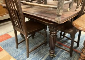 A Gillow's style mahogany dinning table on reeded legs to brass caps and castors with three leaves,