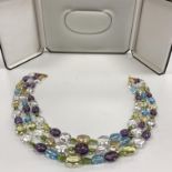 A modern three row necklace of multi-coloured semi precious polished boulder beads strung to an 18