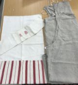 A collection of linen sheets with embroidered initials and other linen items
