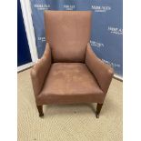 A late 19th Century upholstered armchair on square tapered front legs to brass caps and china