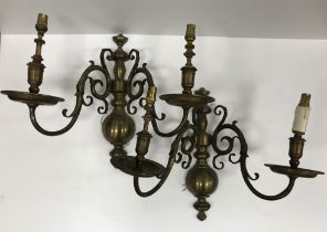 A pair of Dutch style brass twin branch wall lights,