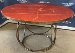 A mid to late 20th Century brass framed circular dining table with red leather top on medallion