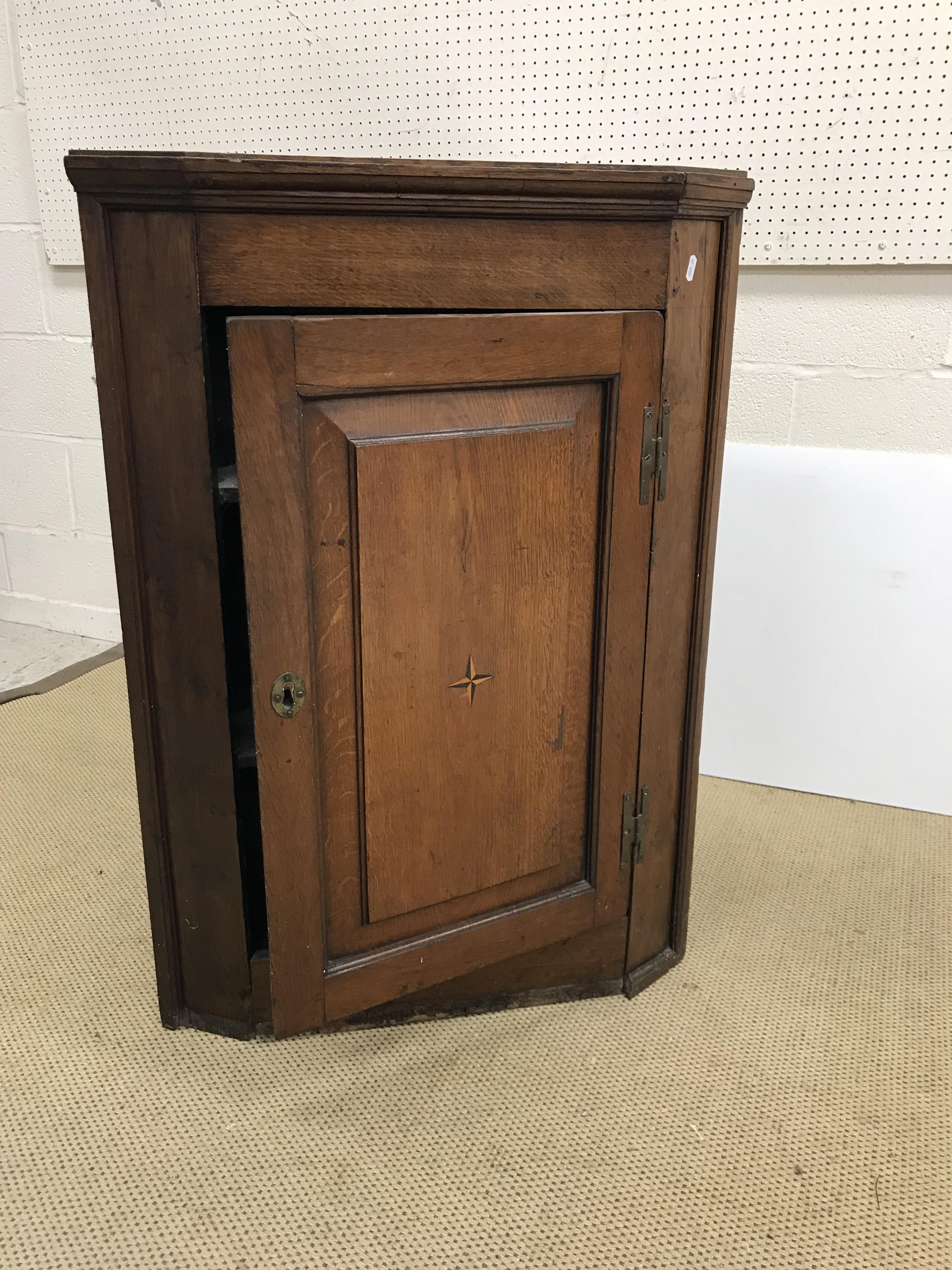 A George III oak hanging corner cupboard,