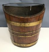 A 19th Century mahogany and brass bound coopered bucket of oval form with narrow brass swing handle
